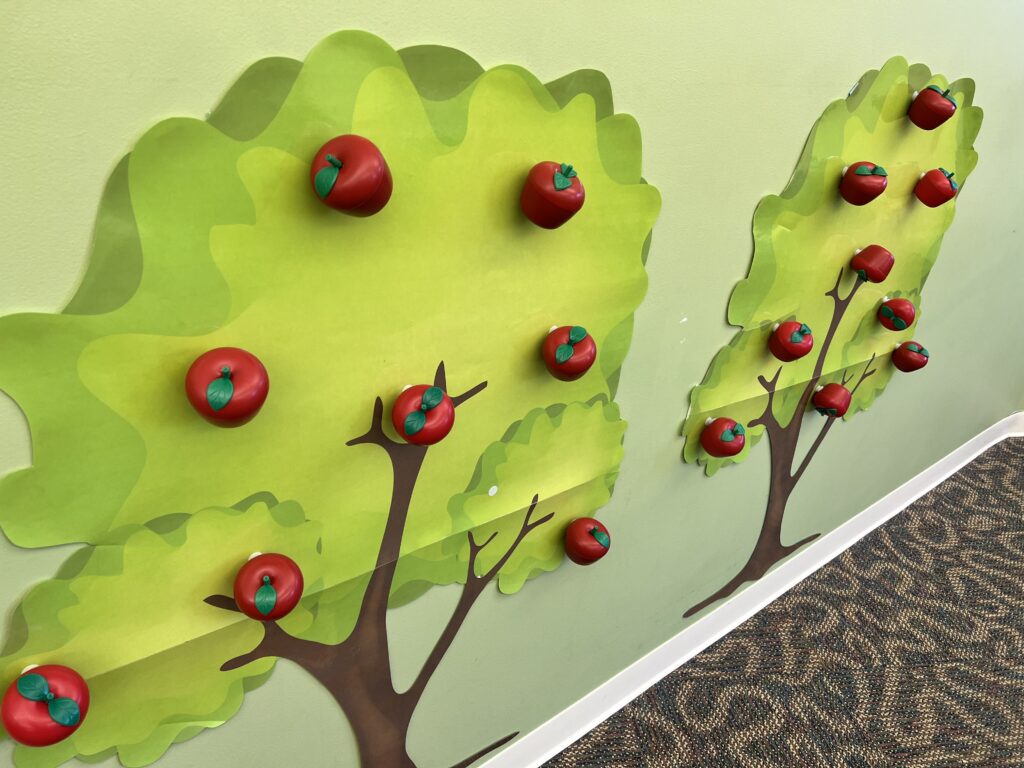 Posters of trees with plastic apples attached